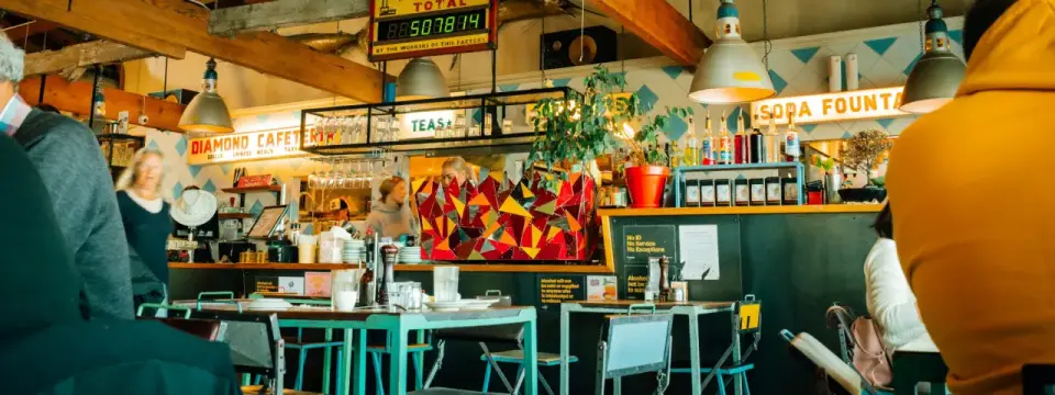 A wide Whittle crop of the café photograph, keeping the colourful counter and turquoise seating in view.